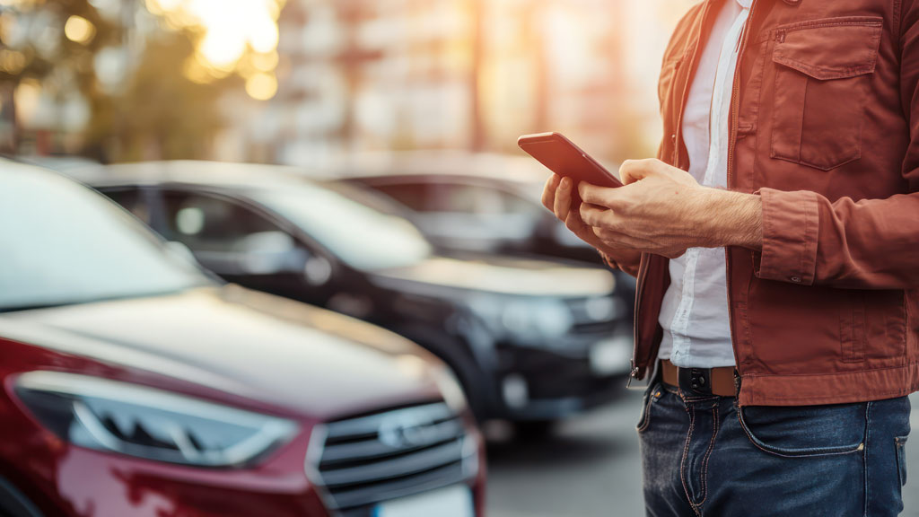 Personne réservant parking CDG sur ordinateur portable dans salon